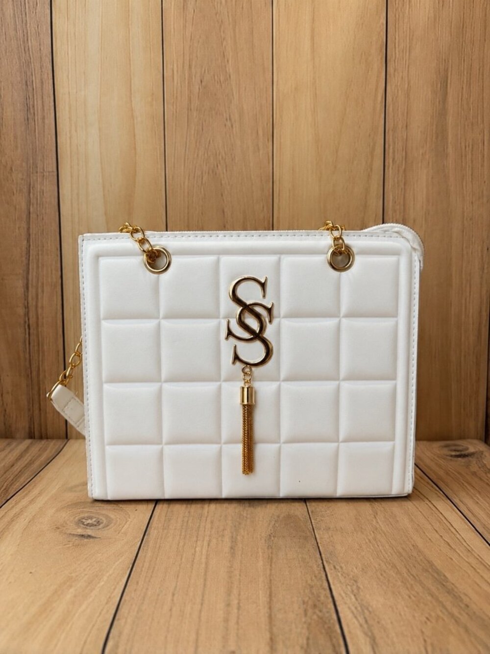 White quilted handbag featuring elegant gold-tone hardware